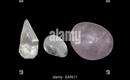 Silica row. Three quartz variations, clear crystal point, round pebble and round soft violet colored amethyst, isolated on black Stock Photo