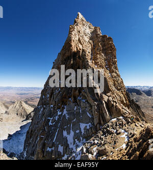 Mount Humphreys summit spire in the Sierra Nevada Mountains with two mountaineers at the base Stock Photo