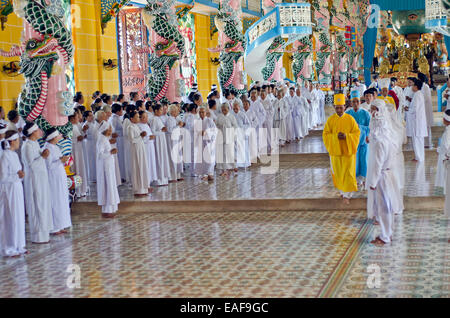 Priests leaving the temple after 12 o'clock ritual,Cao Dai temple ,Tay Ninh ,Vietnam Stock Photo