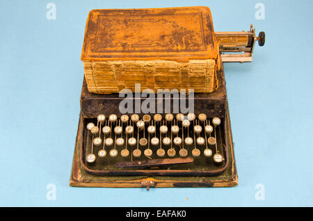 antique typewriter and old book on blue background Stock Photo
