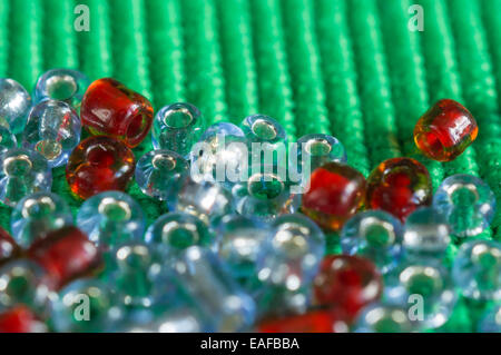 The scattered beads of red and gray color on a green background Stock Photo