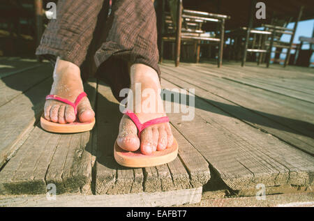 Foot in thongs on the beach Stock Photo