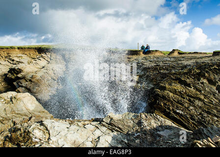 Spray from waves crashing onto rocks on Porth Island in Newquay. Stock Photo