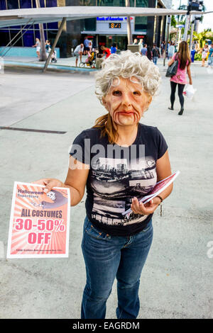 Miami Beach Florida,Lincoln Road,pedestrian mall,Halloween,costume,woman female women,wearing,mask,scary face,handing out flyers,FL141031040 Stock Photo