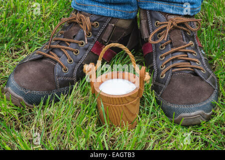 Women hold small wooden mug of milk Stock Photo