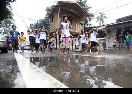 Pasig City, Philippines. 15th Nov, 2014. Residents run while carrying a hut during the Buhat Kubo Race as part of the Bayanihan Festival in Pasig City, the Philippines, on November 15, 2014. Residents take part in the annual festival that brings together community members to celebrate the spirit of 'bayanihan', the willing sharing of any heavy load for the good of mankind. Credit:  Rouelle Umali/Xinhua/Alamy Live News Stock Photo