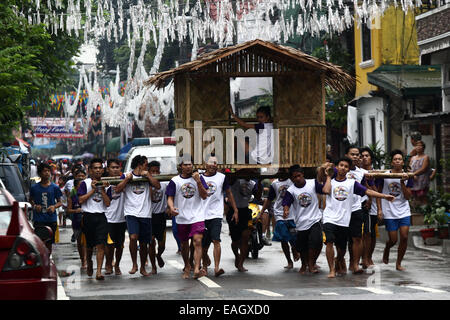 Pasig City, Philippines. 15th Nov, 2014. Residents run while carrying a hut during the Buhat Kubo Race as part of the Bayanihan Festival in Pasig City, the Philippines, on November 15, 2014. Residents take part in the annual festival that brings together community members to celebrate the spirit of 'bayanihan', the willing sharing of any heavy load for the good of mankind. Credit:  Rouelle Umali/Xinhua/Alamy Live News Stock Photo