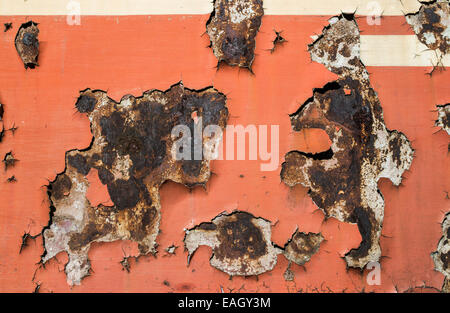 Red cracked paint on rusty iron. Sun light Stock Photo