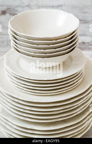 Pile of white porcelain plates lined on white wooden background