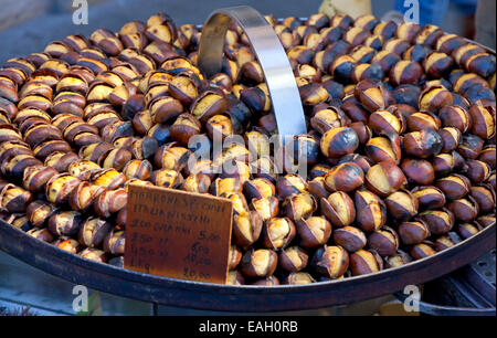 Roasting chestnuts on the grill by a street vendor Stock Photo