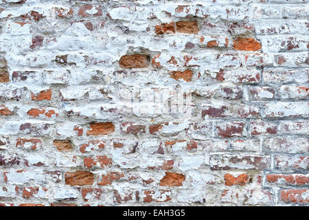 old red brick wall with cracked white painting Stock Photo