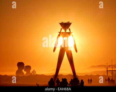 Sunset over the Burning Man statue on the playa at the annual Burning Man festival in the desert August 26, 2014 in Black Rock City, Nevada. Stock Photo