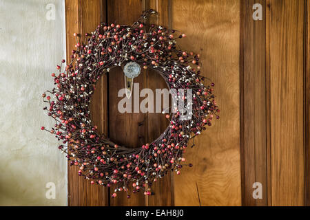 A Christmas wreath hangs on an old door. With vintage effects. Stock Photo