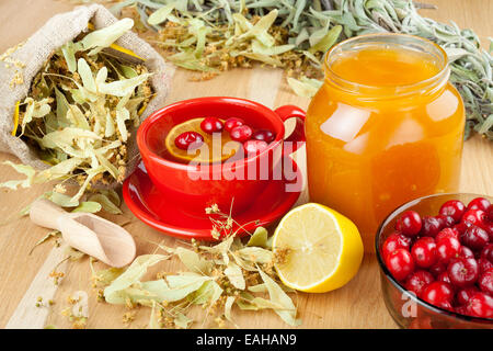 cranberries, jar with honey, fruit tea cup, healing herbs and lemon Stock Photo