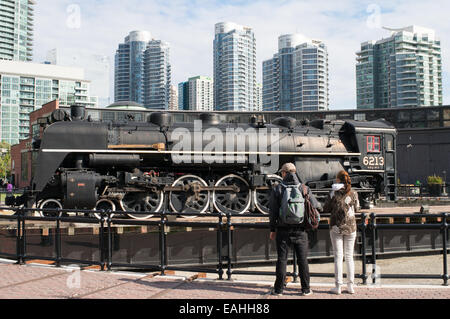Couple looking at  steam train 6213 on turntable at John Street Roundhouse, Toronto, Ontario, Canada Stock Photo
