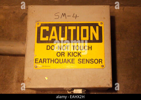 Caution sign near earthquake sensor inside Hoover Dam. Stock Photo