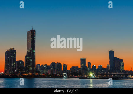 The sun sets behind the skyscrapers of Seoul, South Korea. Stock Photo