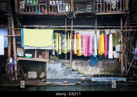 Colourful washing hangs from a traditional wooden building, Fenghuang, China Stock Photo