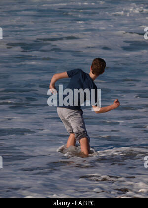 Boy skimming stones in the sea, Bude, Cornwall, UK Stock Photo
