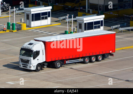 Iveco truck and red soft sided trailer with side curtain  access departing check in booth Dover Ferry Port Kent England UK Stock Photo