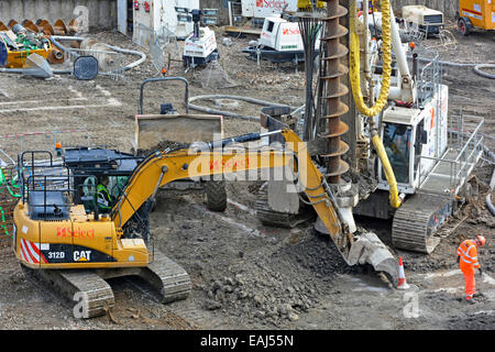 Auger piling rig & excavator machinery work on foundations for housing development on building construction industry site Southwark London England UK Stock Photo