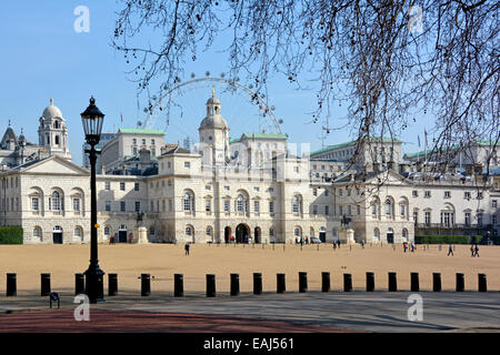Horse Guards buildings and the Parade Ground behind Whitehall with security bollards and The London Eye ferris wheel beyond Stock Photo