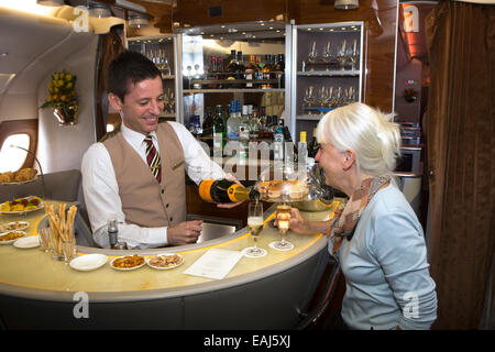 Emirates Airline, barman pouring champagne in bar of A380 Business Class cabin Stock Photo