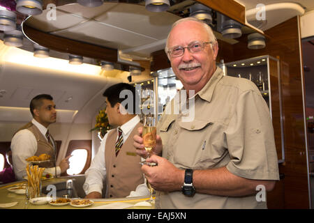 Emirates Airline, male passenger with champagne in bar of A380 Business Class cabin Stock Photo