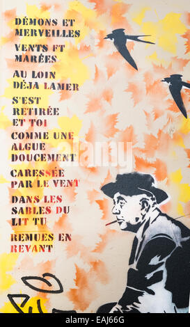 graffito showing french poet jacques prévert sitting on a chair next to the lyrics of the chanson demons et merveilles Stock Photo