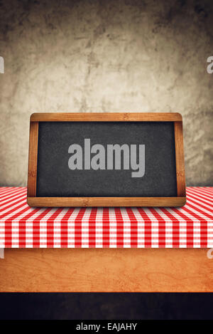 Blank Slate as Copy Space on kitchen table covered with checkered table cloth Stock Photo