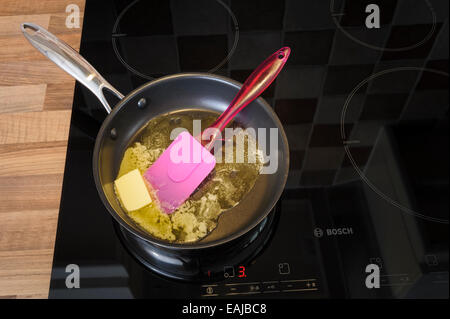 Butter melting in a frying pan, on an induction hob.Unhealthy, cholestrol. Stock Photo