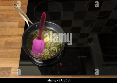 Butter melting in a frying pan, on an induction hob.Unhealthy, cholestrol. Stock Photo