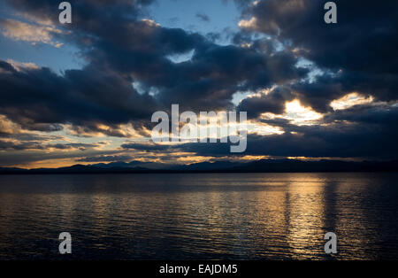 The sun sets across Lake Champlain in Shelburne, Vermont with New York's Adirondack Mountains on the horizon. Stock Photo