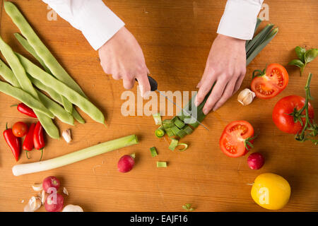 Chef Chopping Vegetables On A Wooden Cutting Board Stock Photo, Picture and  Royalty Free Image. Image 32124885.