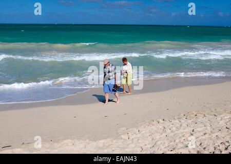 Older couple walking on the beach in Oahu, Hawaii Stock Photo