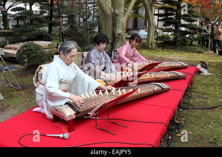 Japanese women in kimono playing koto (Japanese traditional instrument) in Japanese garden Stock Photo