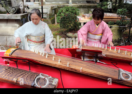 Japanese women in kimono playing koto (Japanese traditional instrument) in Japanese garden Stock Photo