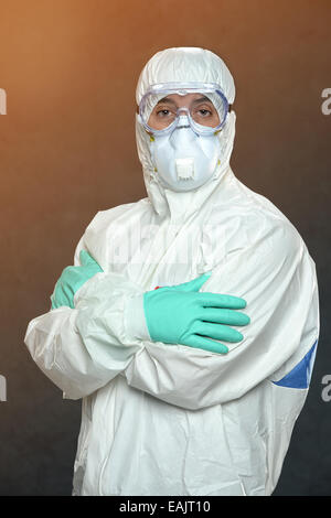 Scientist in Hazmat suit and protective gear with arms crossed Stock Photo