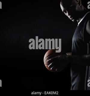 Studio shot of strong young man holding basketball looking at camera with copy space. African basketball player. Stock Photo