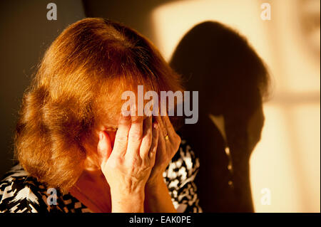 Tearful woman covering her face with both hands. Stock Photo