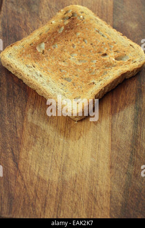 Toast on brown chopping board. Stock Photo