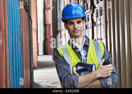 Worker standing between cargo containers Stock Photo