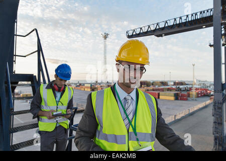 Businessman smiling near cargo crane Stock Photo