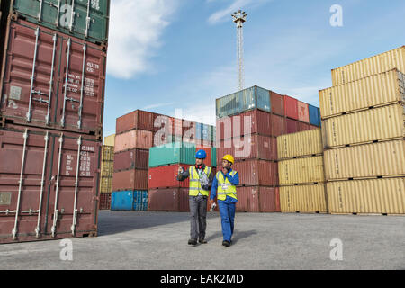 Worker and businessman talking near cargo containers Stock Photo