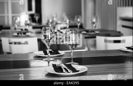 Elegante tavolo con set di piatti bianchi e neri, bicchieri da vino e si  Foto stock - Alamy