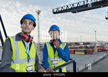 Workers standing on cargo crane Stock Photo