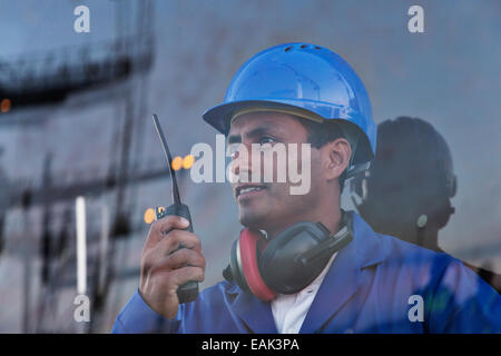 Worker holding walkie-talkie near window Stock Photo