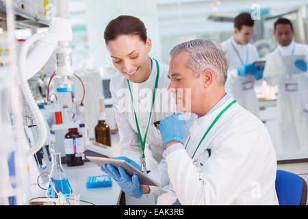 Scientists using tablet computer in laboratory Stock Photo