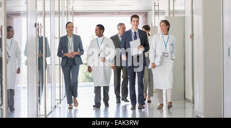 Scientists and business people walking in hallway Stock Photo