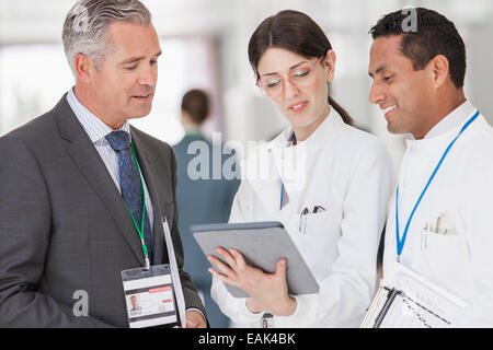 Scientists and businessman reading digital tablet Stock Photo